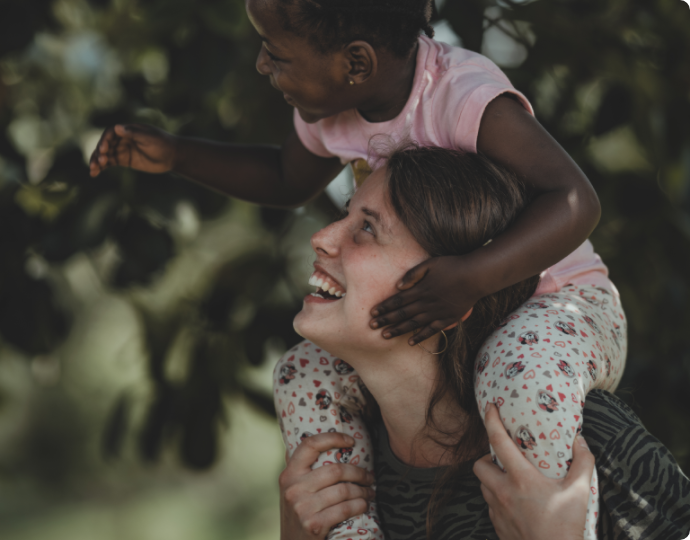 Missionary laughing with child on their shoulders